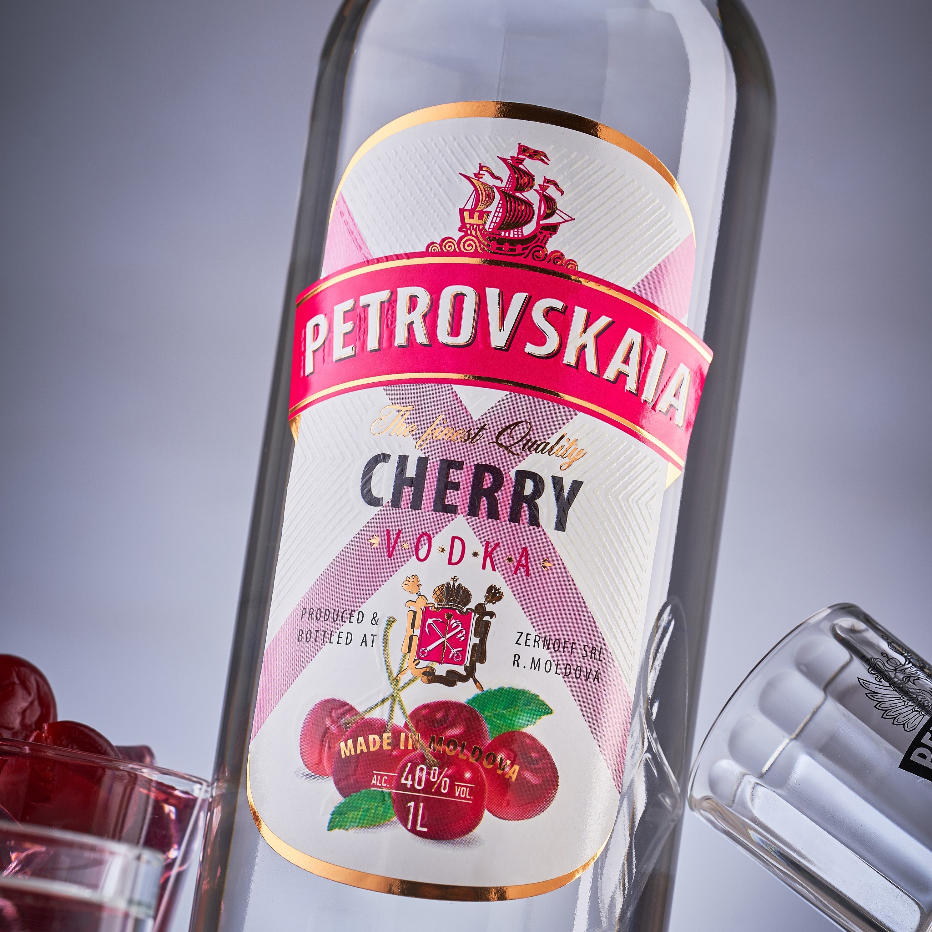 Close-up van de fles Petrovskaia Cherry Premium Vodka 1 liter fles met kersen en cocktails
